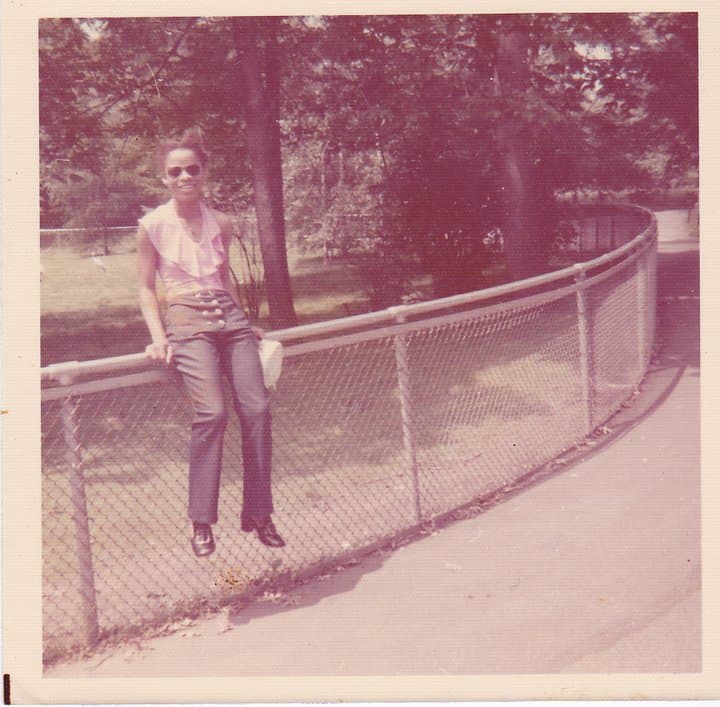 Celia sitting on a park fence